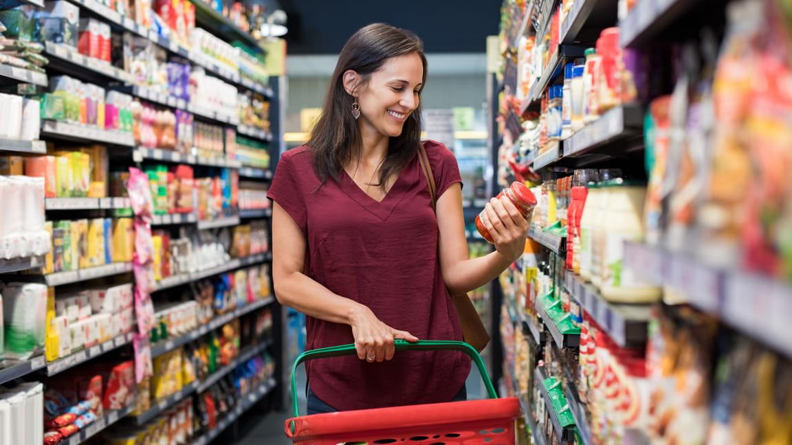 Caucasian woman reading food label in grocery store isle